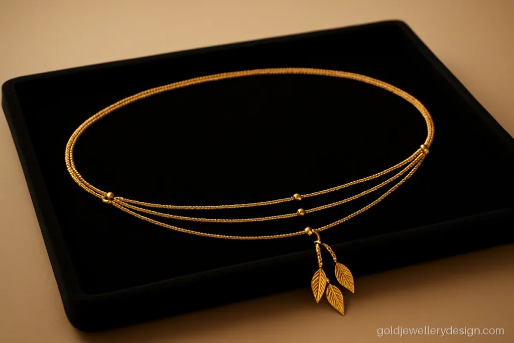 Light kamarband design gold with three fine chains and small leaf tassels