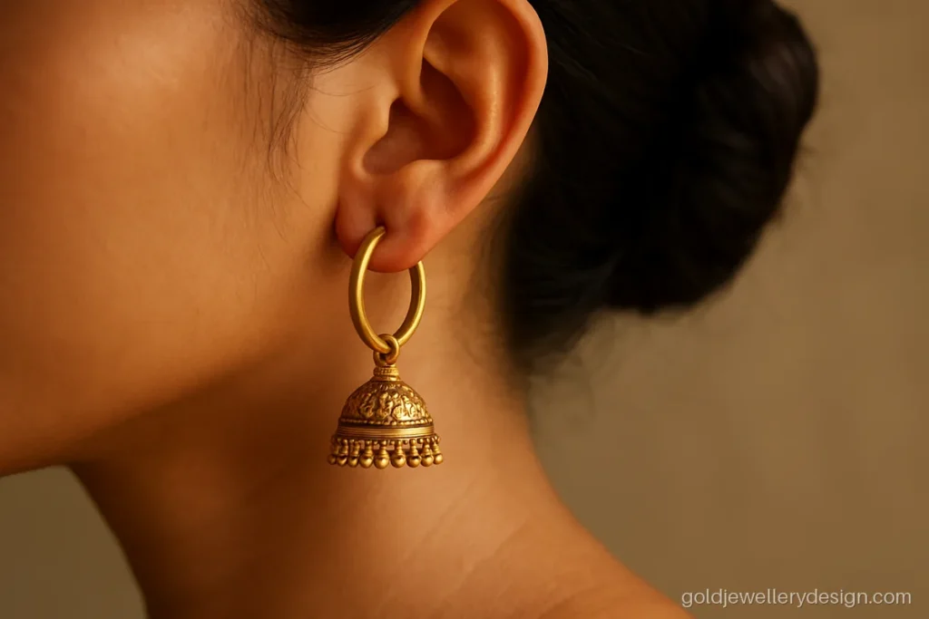 Gold earrings bali design with a small jhumka drop worn with a silk saree