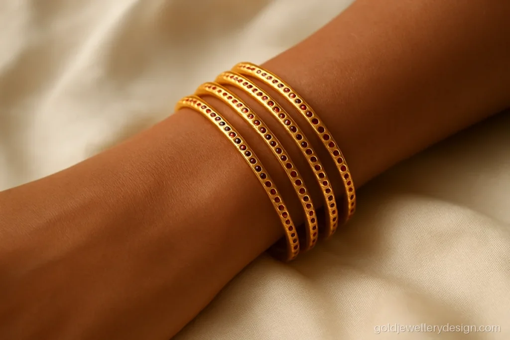 Gold churi design set with small red enamel dots along each bangle