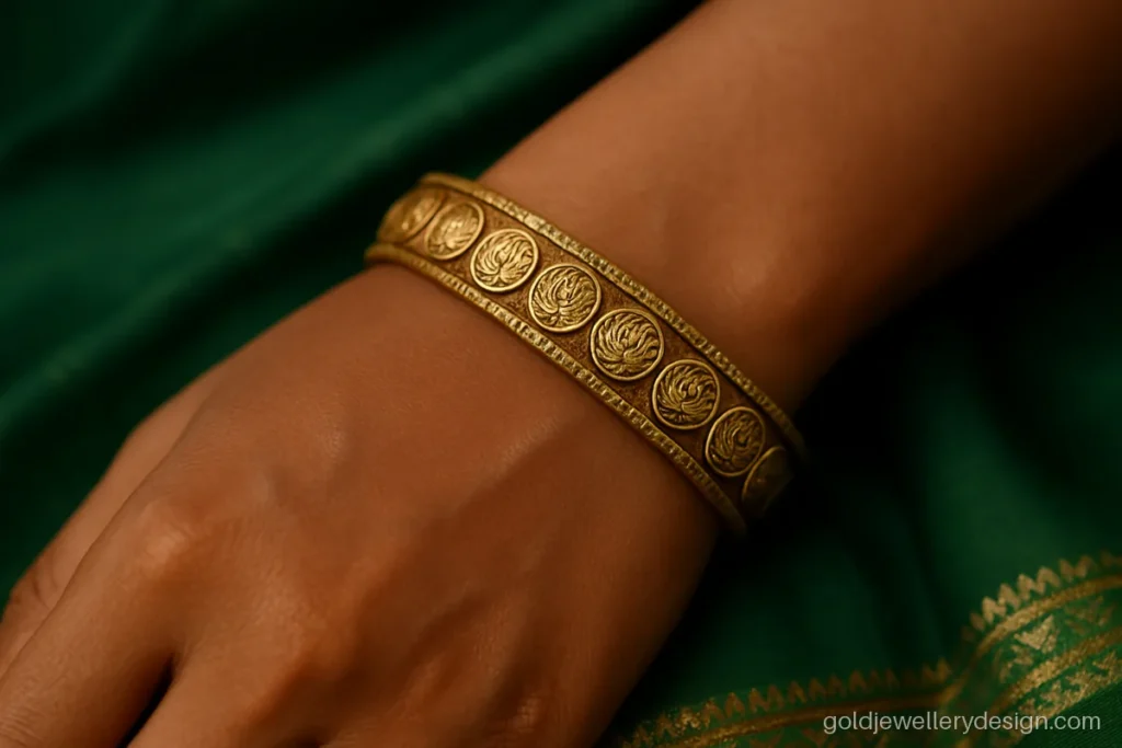Single antique gold bangle with small coin motifs along the edge