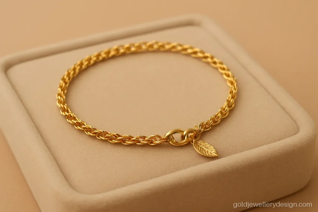 Women bracelet gold design in a Singapore chain with a single leaf drop