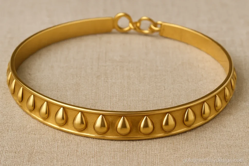 Flat gold choker band with a row of small mango shapes and a hook clasp
