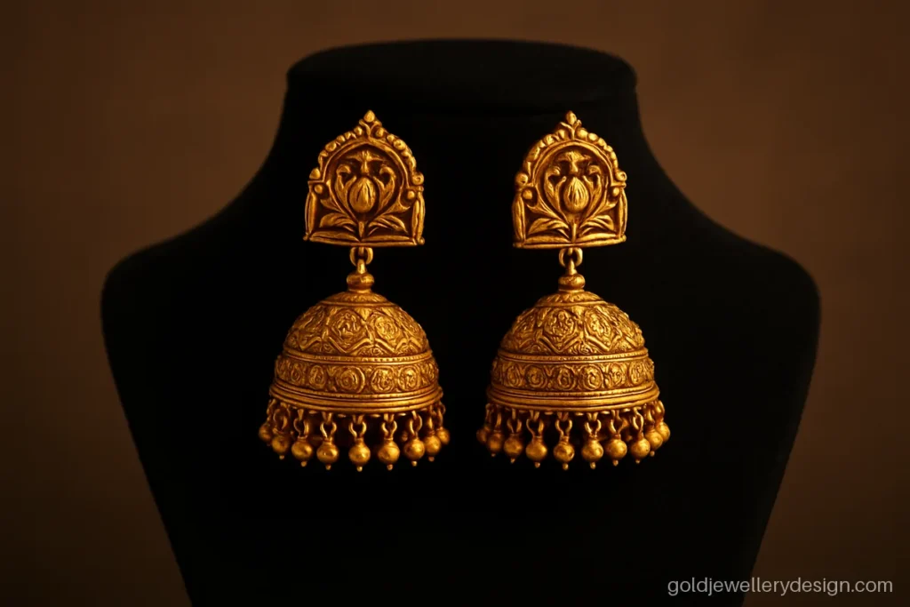 Bridal unique gold earrings design with a temple arch top and heavy jhumka bell