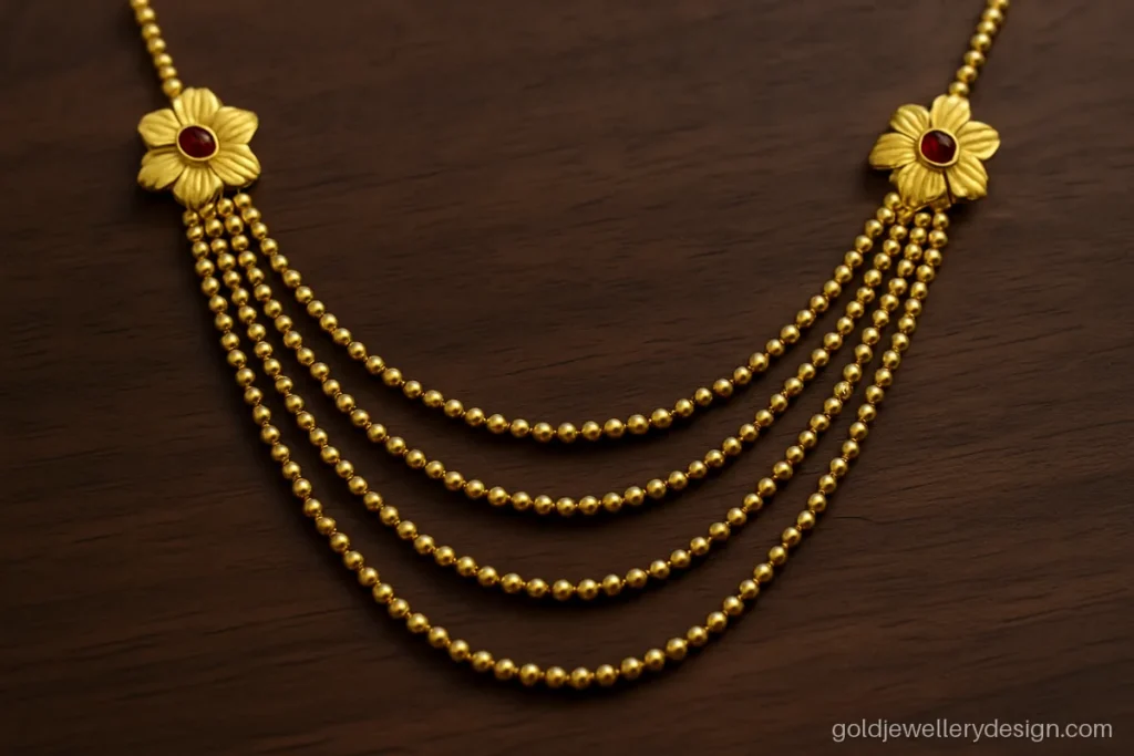 Gold sitahar design with seven thin ball chain strands joined by flower side bars