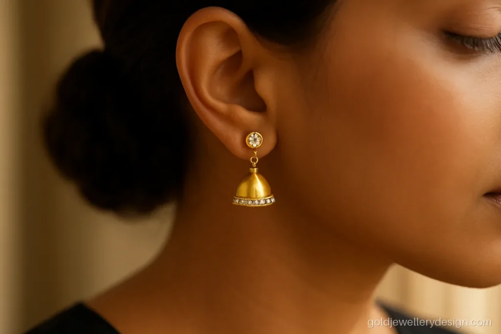 Latest gold jhumka design in 18k with white stones and a slim bell
