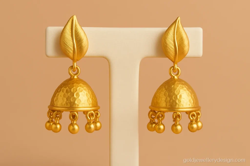 New jhumka design gold pair with leaf stud and a hammered texture bell
