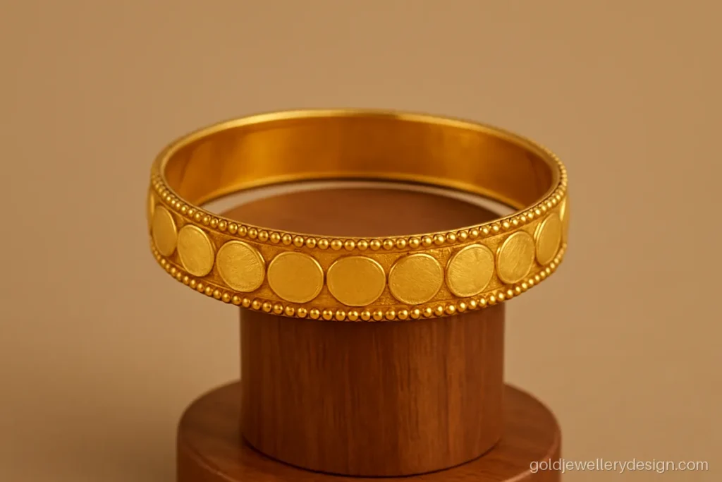 Kada gold bangles design with small coin motifs around the band