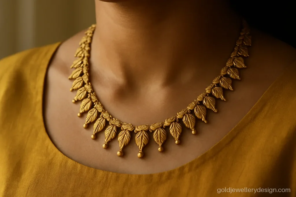 Necklace design gold with antique leaf chain and small hanging bells worn with a blouse