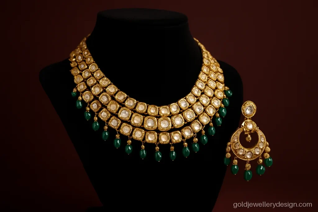 Heavy bridal wedding gold necklace design with polki-look stones and emerald drops on a bust