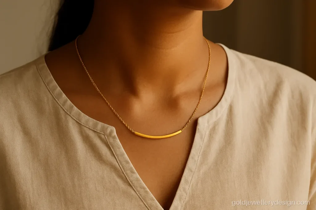 Women's gold necklace design with a curved bar centre worn with a plain kurta