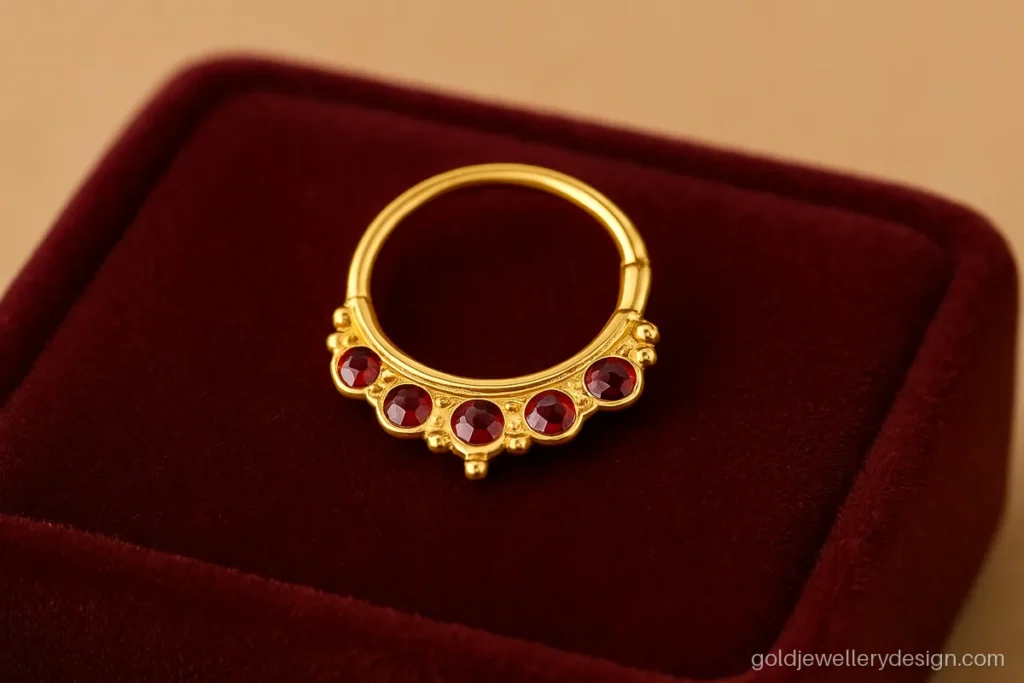 Nose ring gold design with a red stone crescent and tiny gold balls