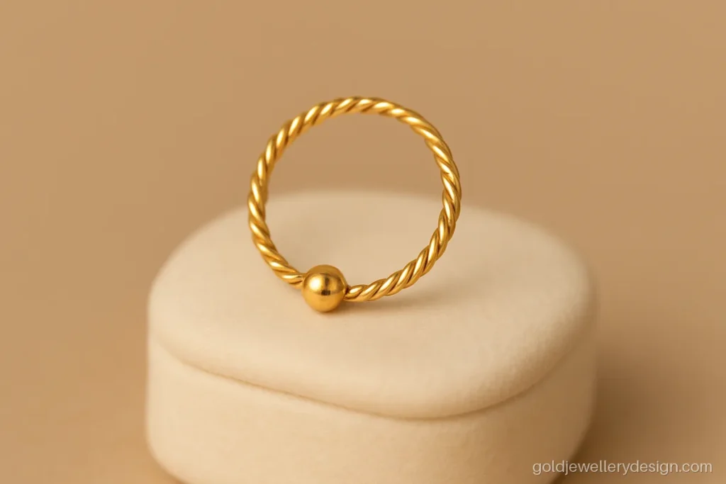 Women's nose ring gold design with a twisted wire and one tiny gold bead