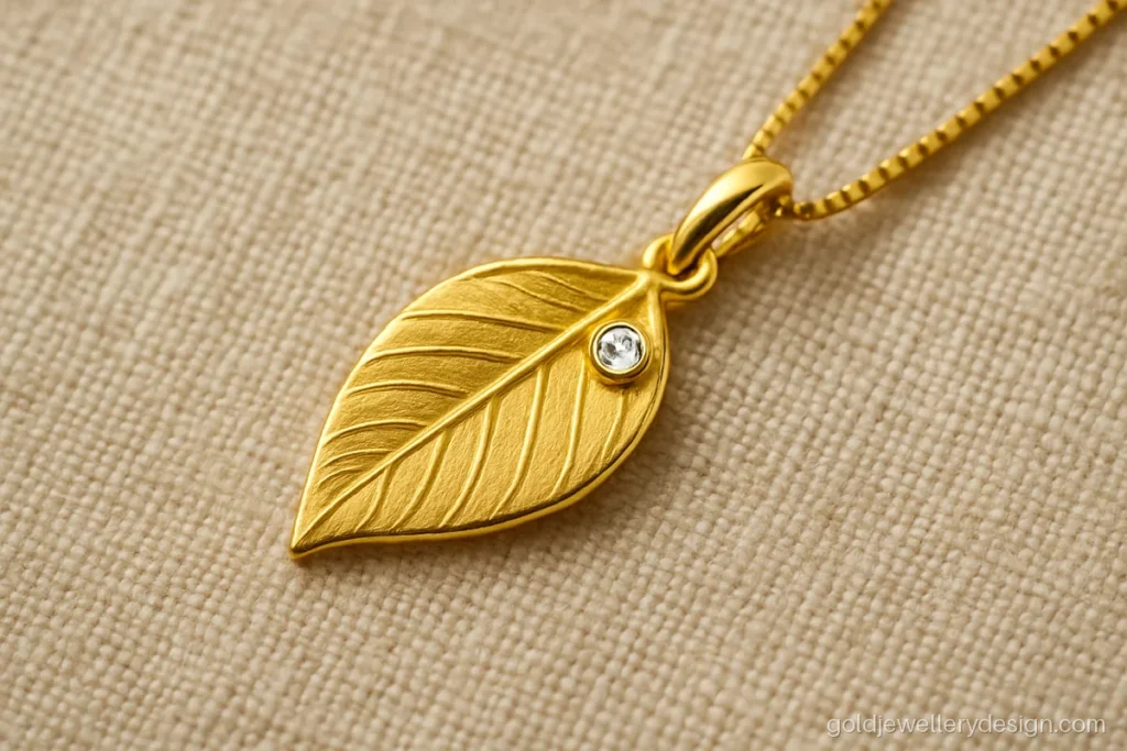 2 gram gold pendant design of a single leaf with matte veins and one CZ