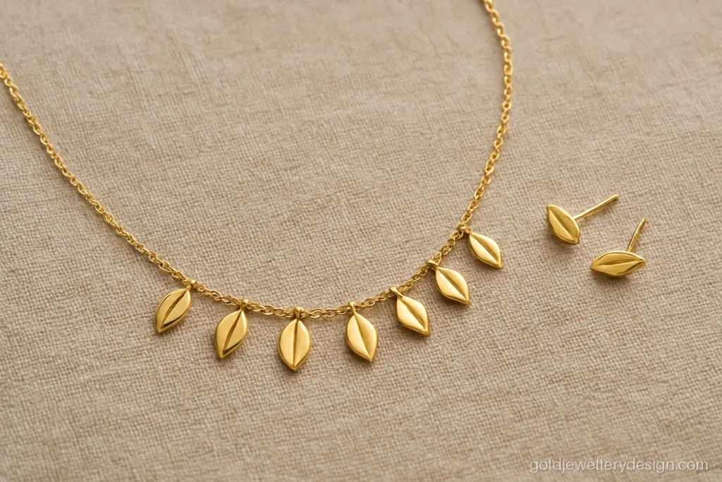 Simple gold set design with a fine leaf necklace and small leaf studs