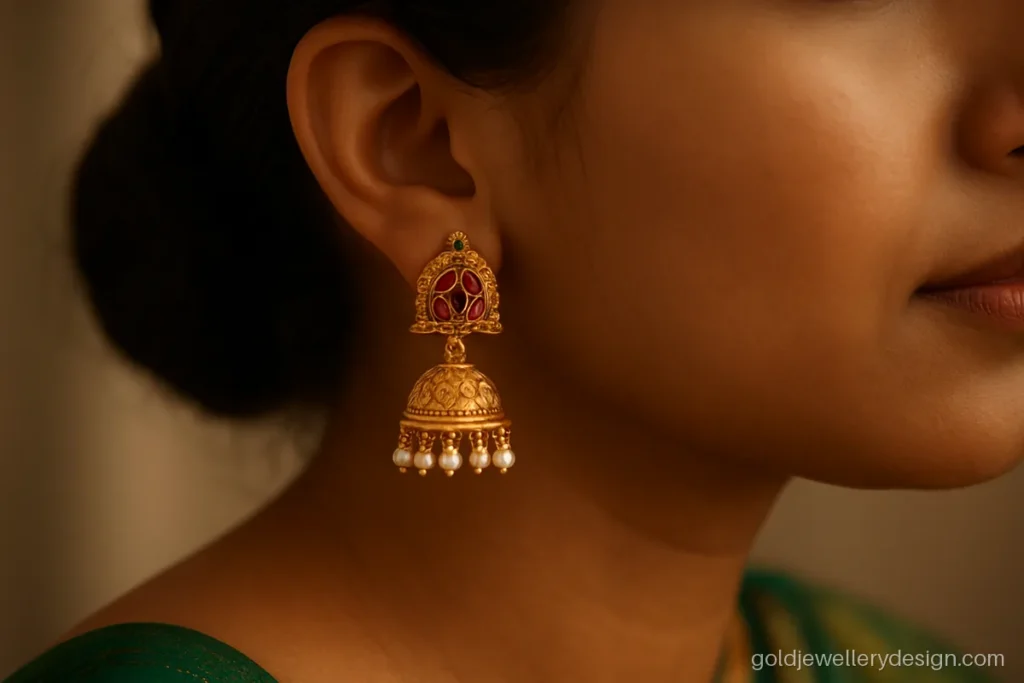 Gold jimiki design with red and green kemp-look stones worn with a silk saree