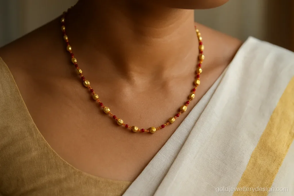 Gold kanthi chain design with coral and gold beads worn with a cotton saree