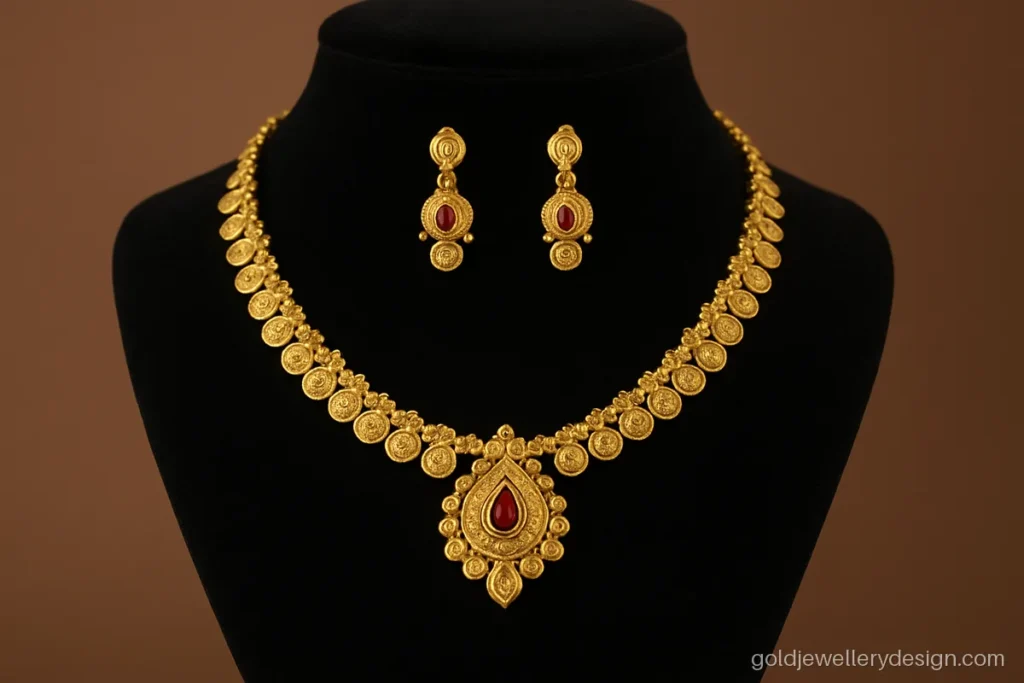 Short kasu malai with a ruby studded centre pendant on a jewellery bust