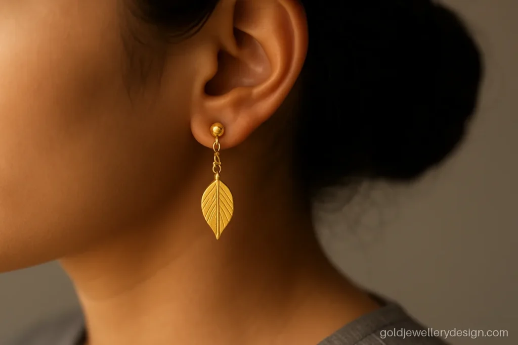 Drop earrings gold design with a single matte leaf on a short chain