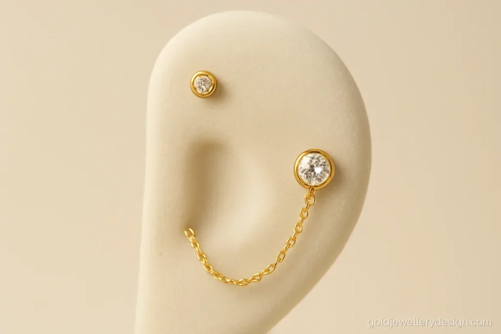 Side earrings gold design with a chain linking the upper ear to the lobe