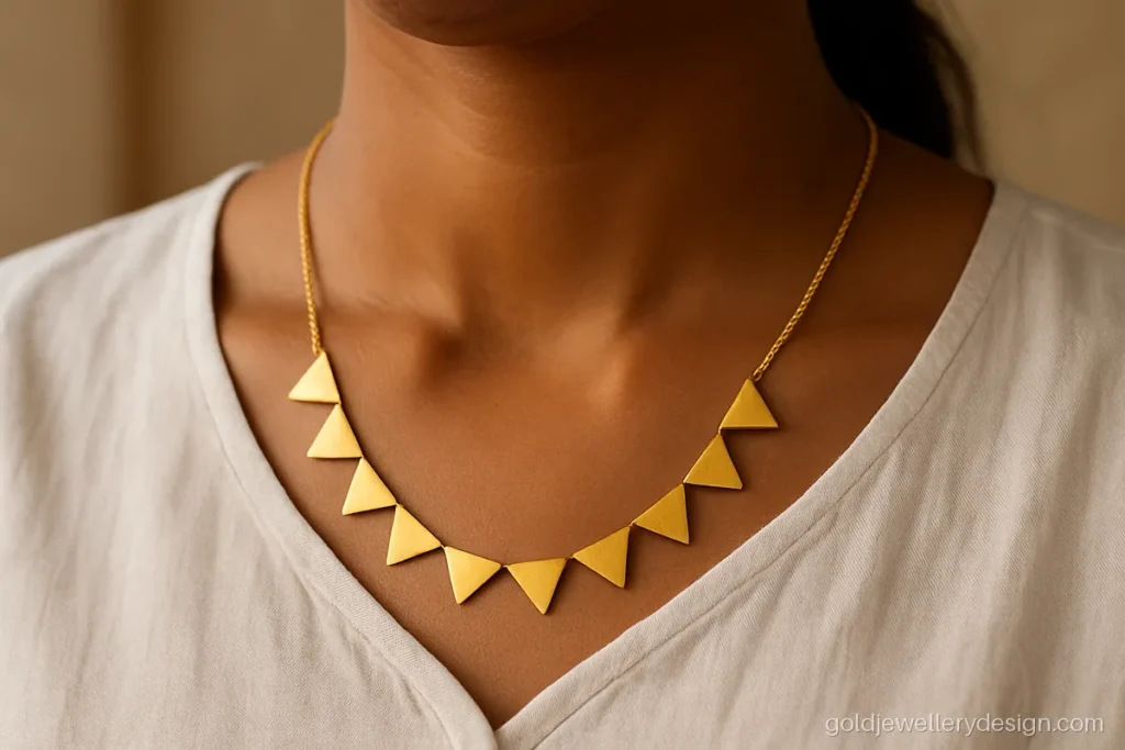 Geometric gold necklace of triangle links worn with a kurta neckline