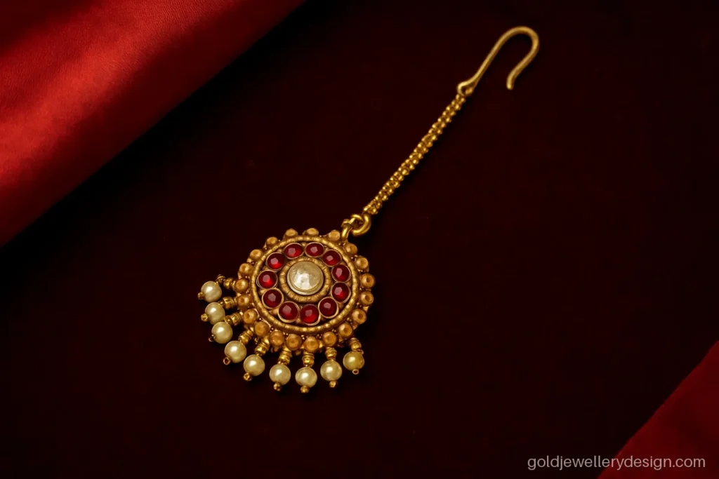 Bridal gold maang tikka design with round ruby pendant and pearl fringe
